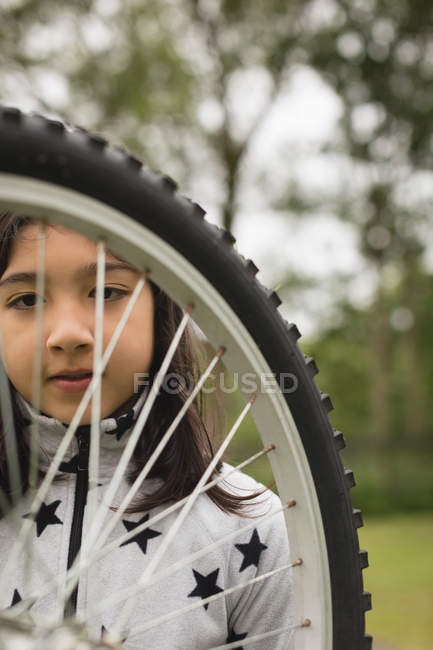 Young girl checking bicycle — Stock Photo