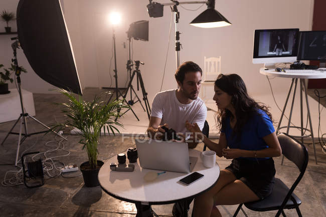 Fotógrafo masculino e modelo feminino interagindo uns com os outros no estúdio de fotografia — Fotografia de Stock