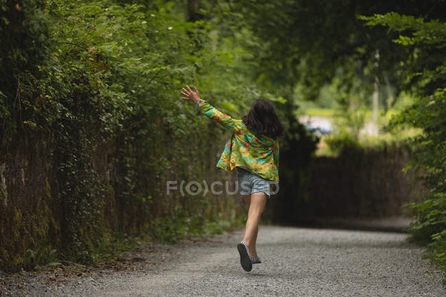 Vista posteriore della ragazza che gioca sulla strada — Foto stock