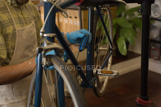 Section médiane du fil de frein de vélo de fixation de mécanicien dans l'atelier — Photo de stock