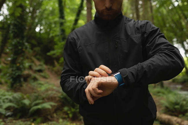 Junger Mann mit Smartwatch im Wald — Stockfoto