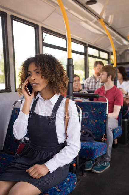 Joven viajera hablando por teléfono móvil mientras viaja en autobús moderno - foto de stock