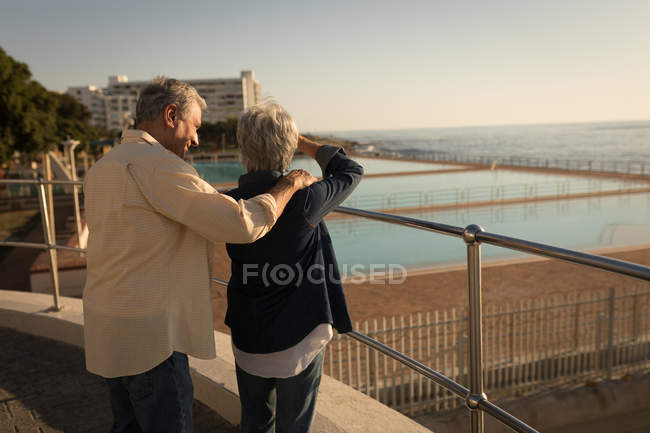 Seniorenpaar steht an einem sonnigen Tag an der Strandpromenade — Stockfoto