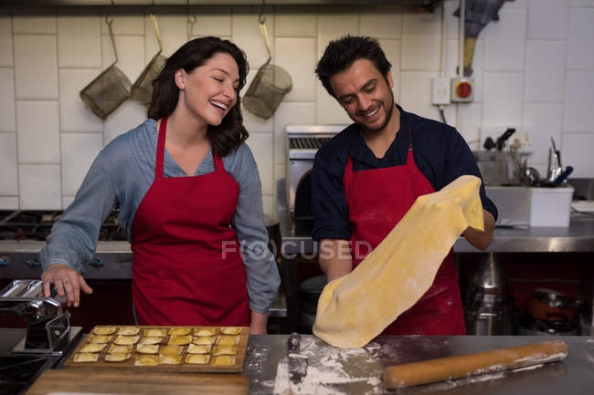 Male baker with other making pasta in bakery — Stock Photo