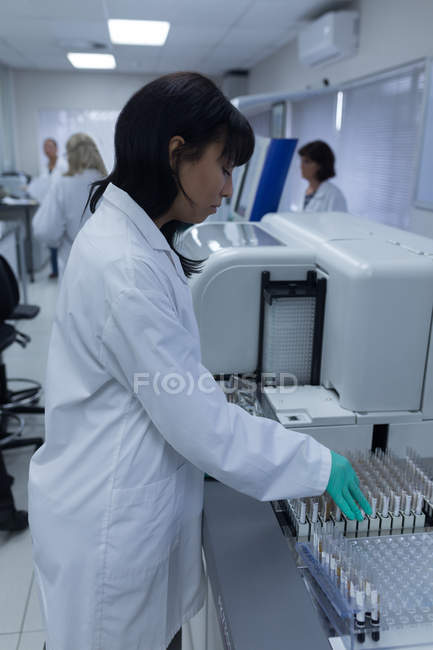 Лабораторний технік, що аналізує хімічний розчин у банку крові — стокове фото