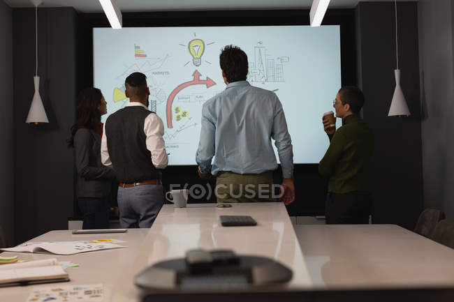Business people discussing over a graph at office — Stock Photo
