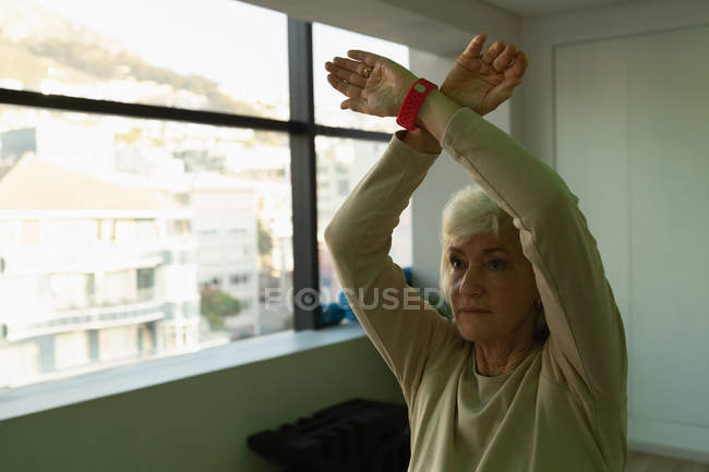 Senior woman performing yoga in yoga center — Stock Photo