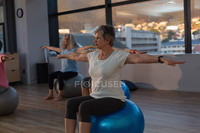 Grupo de mujeres mayores realizando yoga en centro de yoga - foto de stock