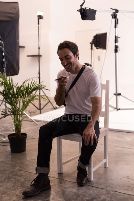Fotógrafo masculino falando no celular no estúdio de fotografia — Fotografia de Stock