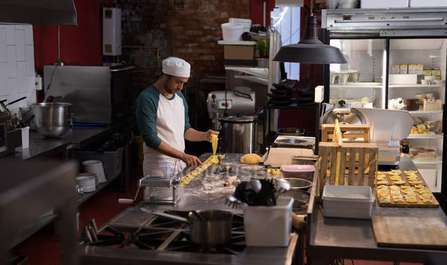 Мужской пекарь готовится к приготовлению макарон — стоковое фото