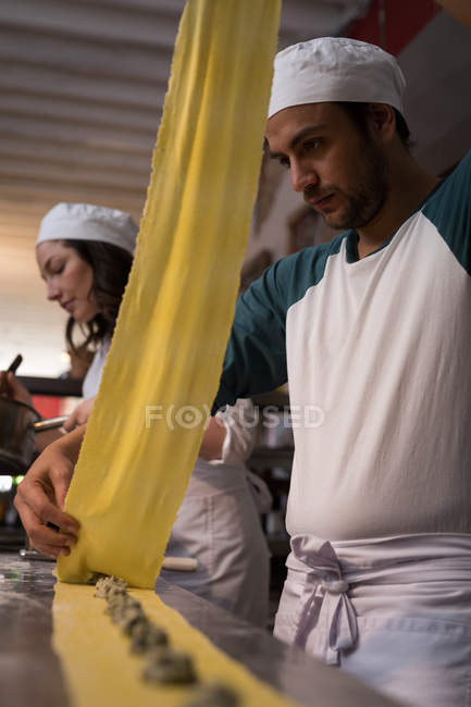 Крупним планом пекарі готують макарони в хлібобулочних виробах — стокове фото