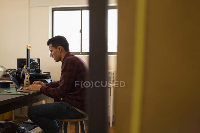 Mechanic using laptop on table in workshop — Stock Photo