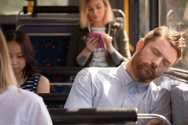 Comutador masculino inteligente dormindo enquanto viaja em ônibus moderno — Fotografia de Stock