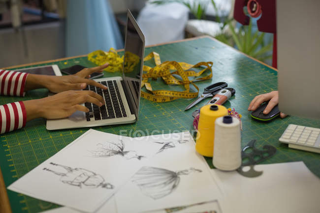 Модный дизайнер с помощью ноутбука в студии моды — стоковое фото