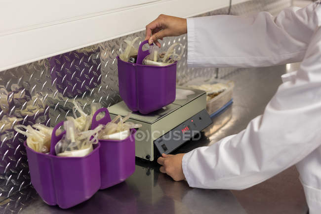 Лаборант проверяет вес пакетов крови в банке крови — стоковое фото