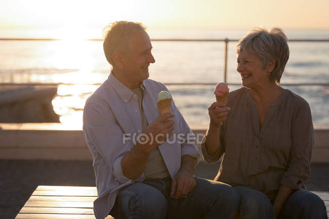 Happy senior couple having ice cream at promenade — Stock Photo