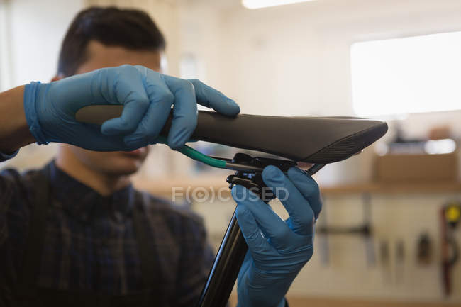 Close-up of man repairing bicycle seat in workshop — Stock Photo