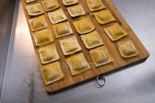 Fresh agnolotti pasta on wooden board in a bakery — Stock Photo
