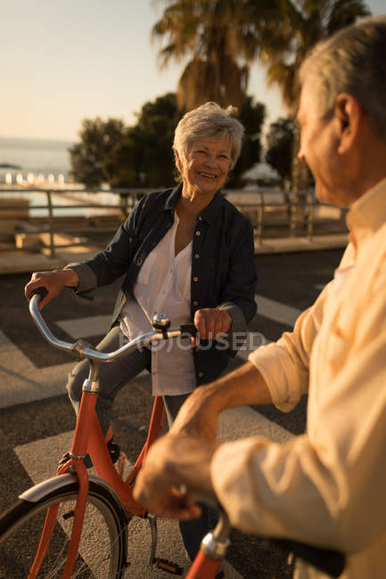 Старшая пара разговаривает друг с другом на набережной в солнечный день — стоковое фото