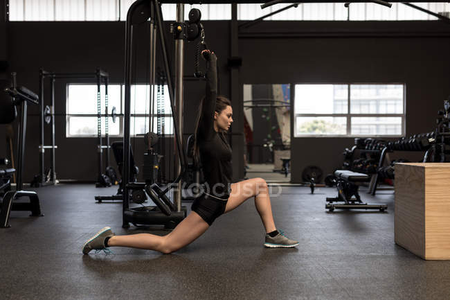 Fit woman doing stretching exercise in fitness studio — Stock Photo