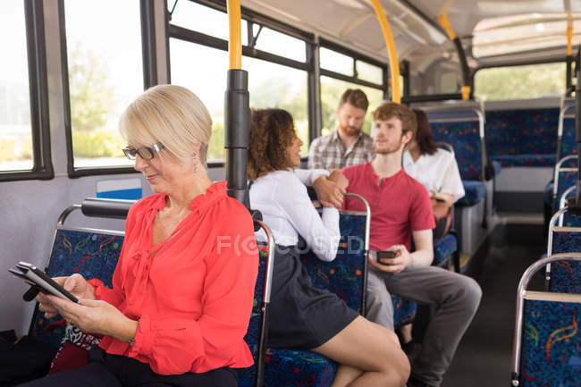 Pendlerin benutzt Handy während der Fahrt in modernem Bus — Stockfoto