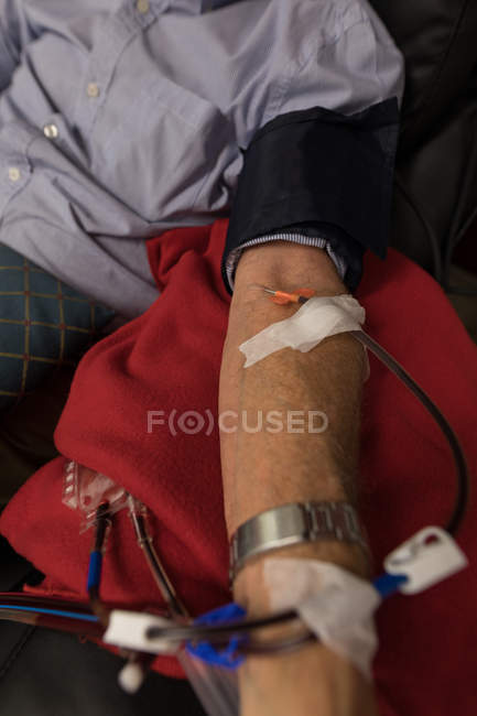 Mid section of senior man donating blood in blood bank — Stock Photo