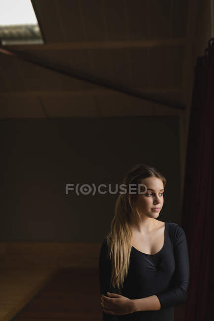 Задумчивая балерина стоит в танцевальной студии — стоковое фото