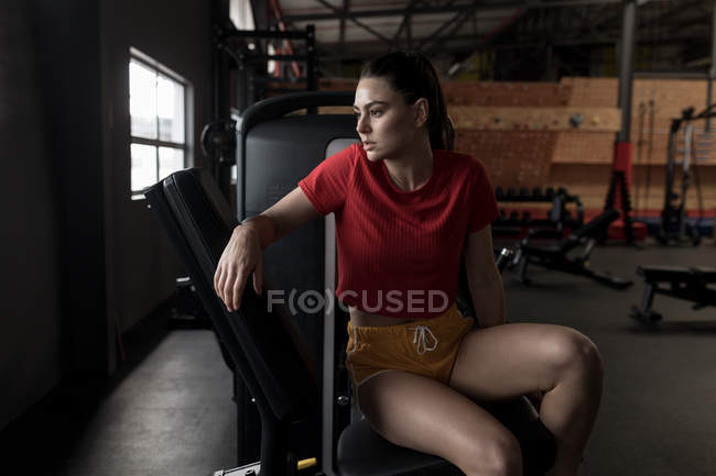 Femme réfléchie relaxant dans un studio de fitness — Photo de stock