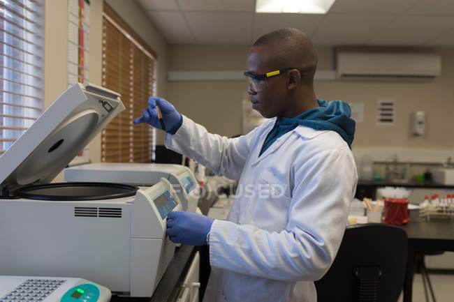 Técnico de laboratório usando máquina de centrífuga refrigerada no banco de sangue — Fotografia de Stock