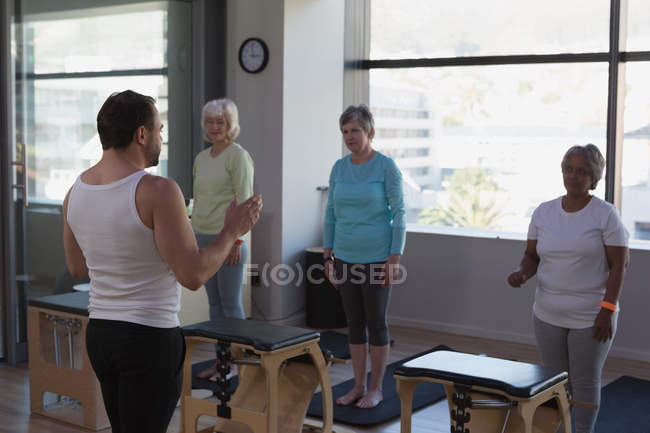 Тренер инструкторской группы пожилых женщин в центре йоги — стоковое фото