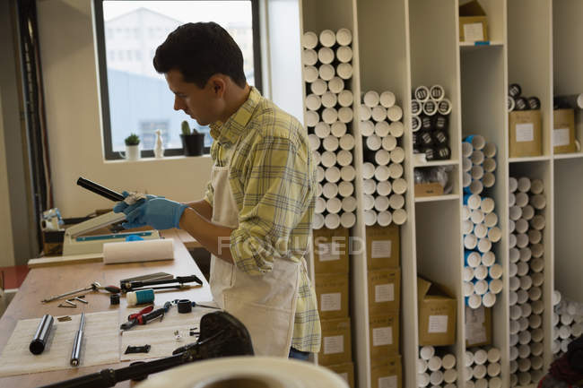 Man cleaning bicycle parts on counter in workshop — Stock Photo