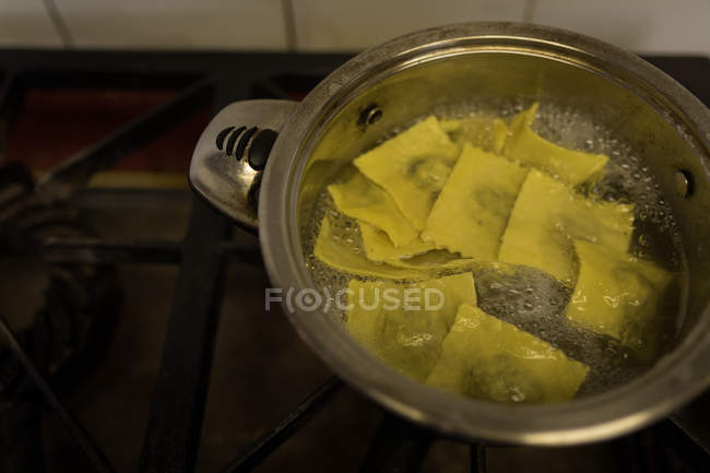 Primo piano della pasta che viene fritta in padella in panetteria — Foto stock