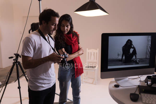 Photographe masculin et mannequin féminin interagissant les uns avec les autres en studio photo — Photo de stock