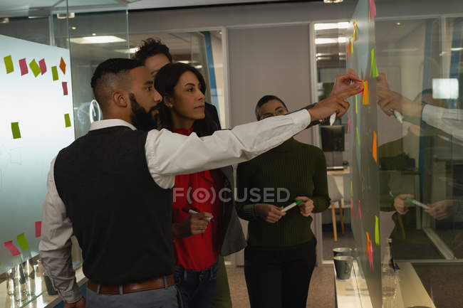 Business people discussing over a sticky notes at office — Stock Photo