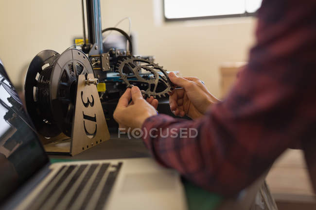 Mechanic checking bicycle chain ring on table in workshop — Stock Photo