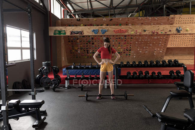Jovem mulher se preparando para levantar barbell no ginásio — Fotografia de Stock