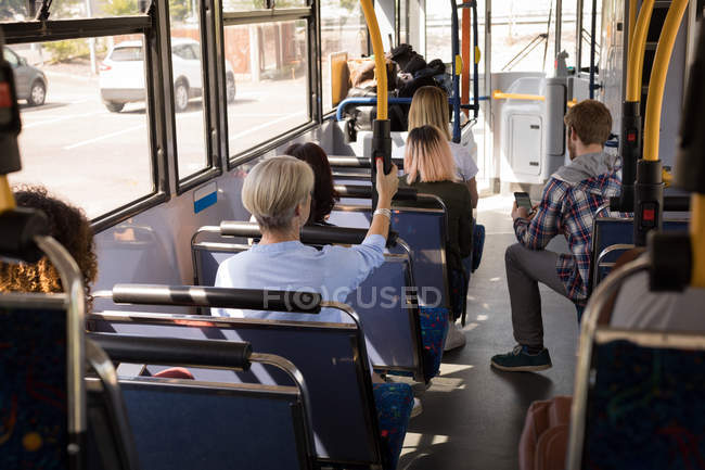 Вид ззаду на комунікатори, що подорожують у сучасному автобусі — стокове фото