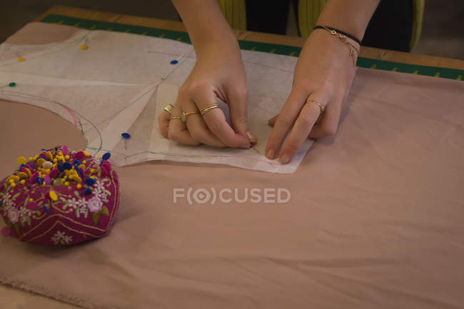 Модный дизайнер вешает на ткань в студии моды — стоковое фото