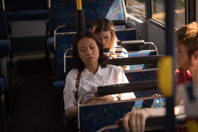 Female commuter using mobile phone while travelling in modern bus — Stock Photo