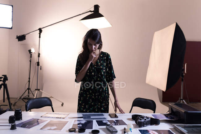 Female photographer looking at photographs in photo studio — Stock Photo