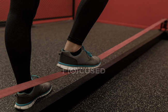 Baixa seção de mulher fazendo exercício com elástico na academia de fitness — Fotografia de Stock