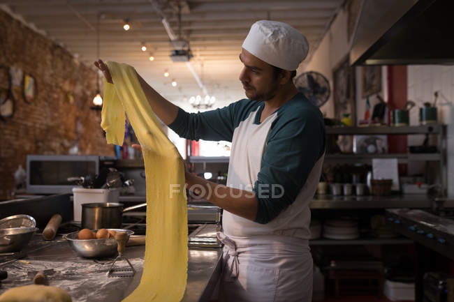 Male baker preparing pasta in bakery — Stock Photo