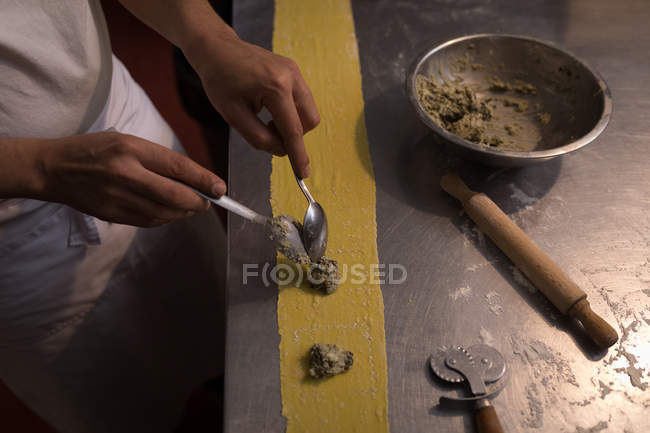 Mid section of baker preparing pasta in bakery — Stock Photo