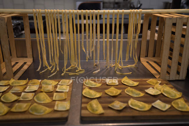 La pasta fresca agnolotti arreglada en la mesa en la panadería - foto de stock
