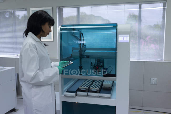 Técnico de laboratório usando comprimido digital no banco de sangue — Fotografia de Stock