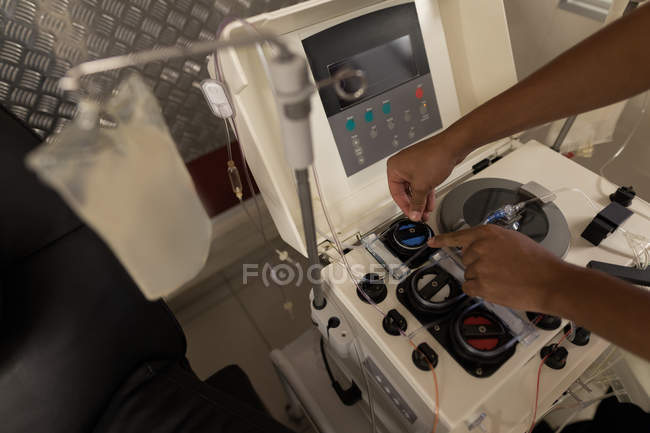 Primer plano del técnico de laboratorio utilizando la máquina en el banco de sangre - foto de stock