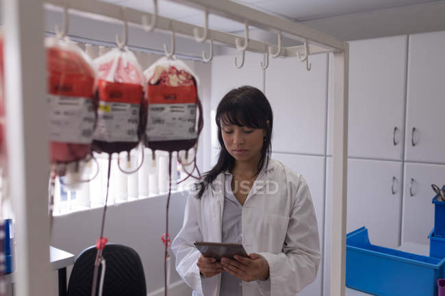 Лабораторный техник, использующий цифровой планшет в банке крови — стоковое фото