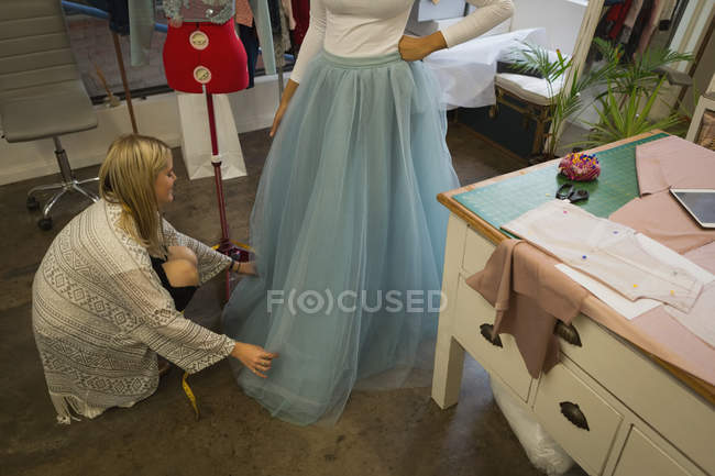 Fashion designer dressing customer in fashion studio — Stock Photo