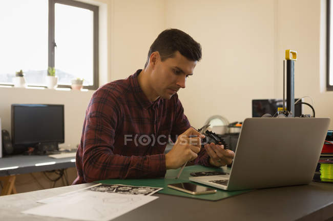 Mechanic checking diameter of chain ring with vernier calipers in workshop — Stock Photo