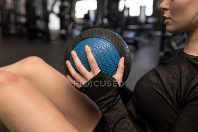 Primo piano della donna che fa esercizio fisico obliquo in palestra — Foto stock